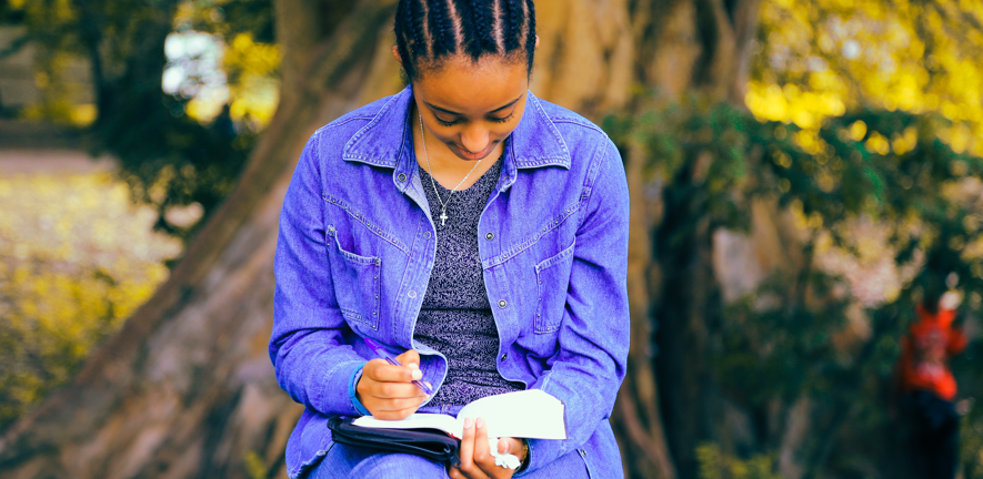 young black woman writing in a diary