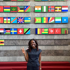 Mastercard Foundation Scholar Kaitochukwu standing in front of flags in AfDB foyer