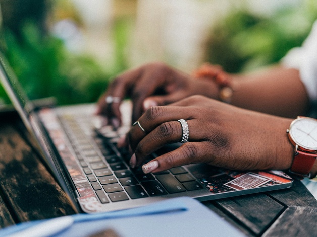 Hands typing on laptop
