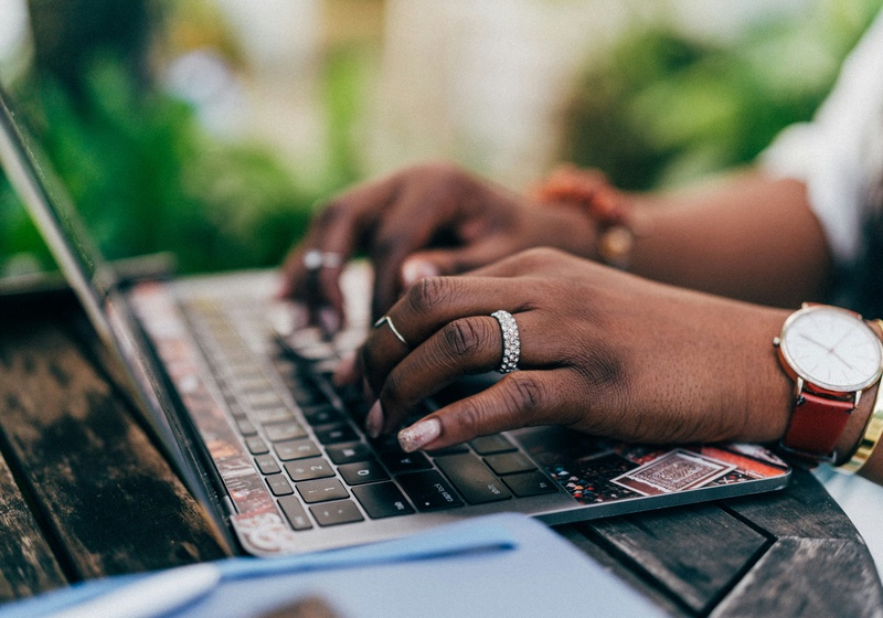 Hands typing on laptop